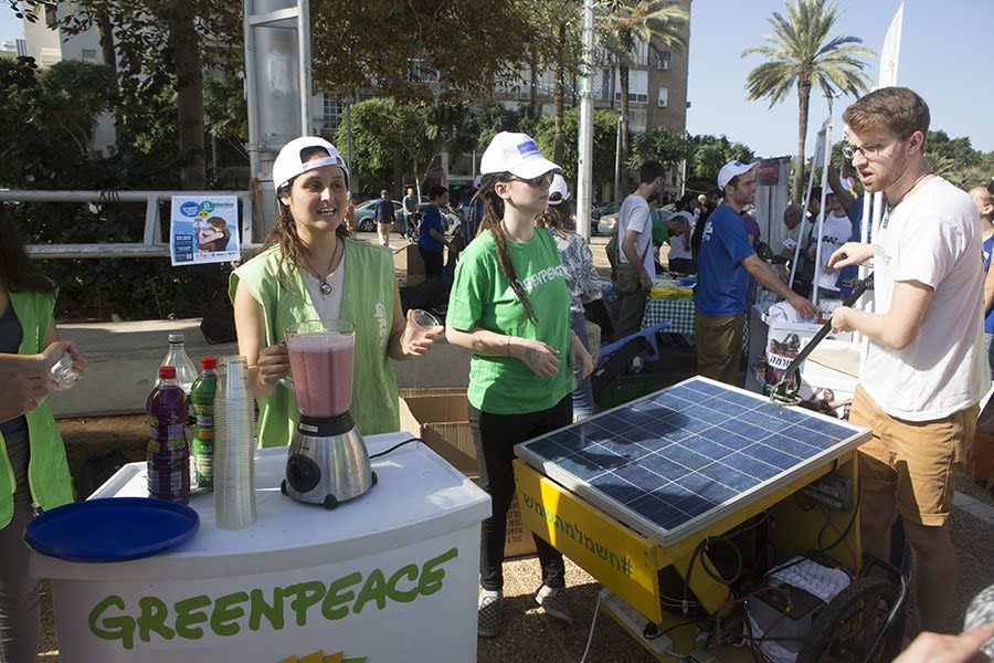 מתנדבי גרינפיס מכינים ברד פטל בעזרת פאנל סולארי